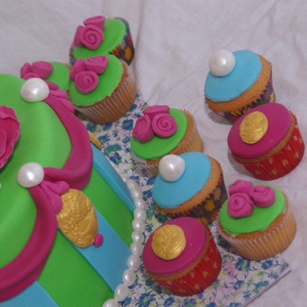 vrolijke groen blauw roze taart met bijpassende cupcakes